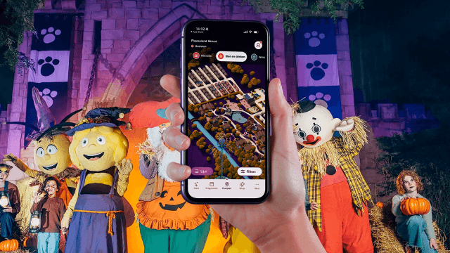 Website Plopsa op mobiele telefoon met op de achtergrond karakters uit het themapark